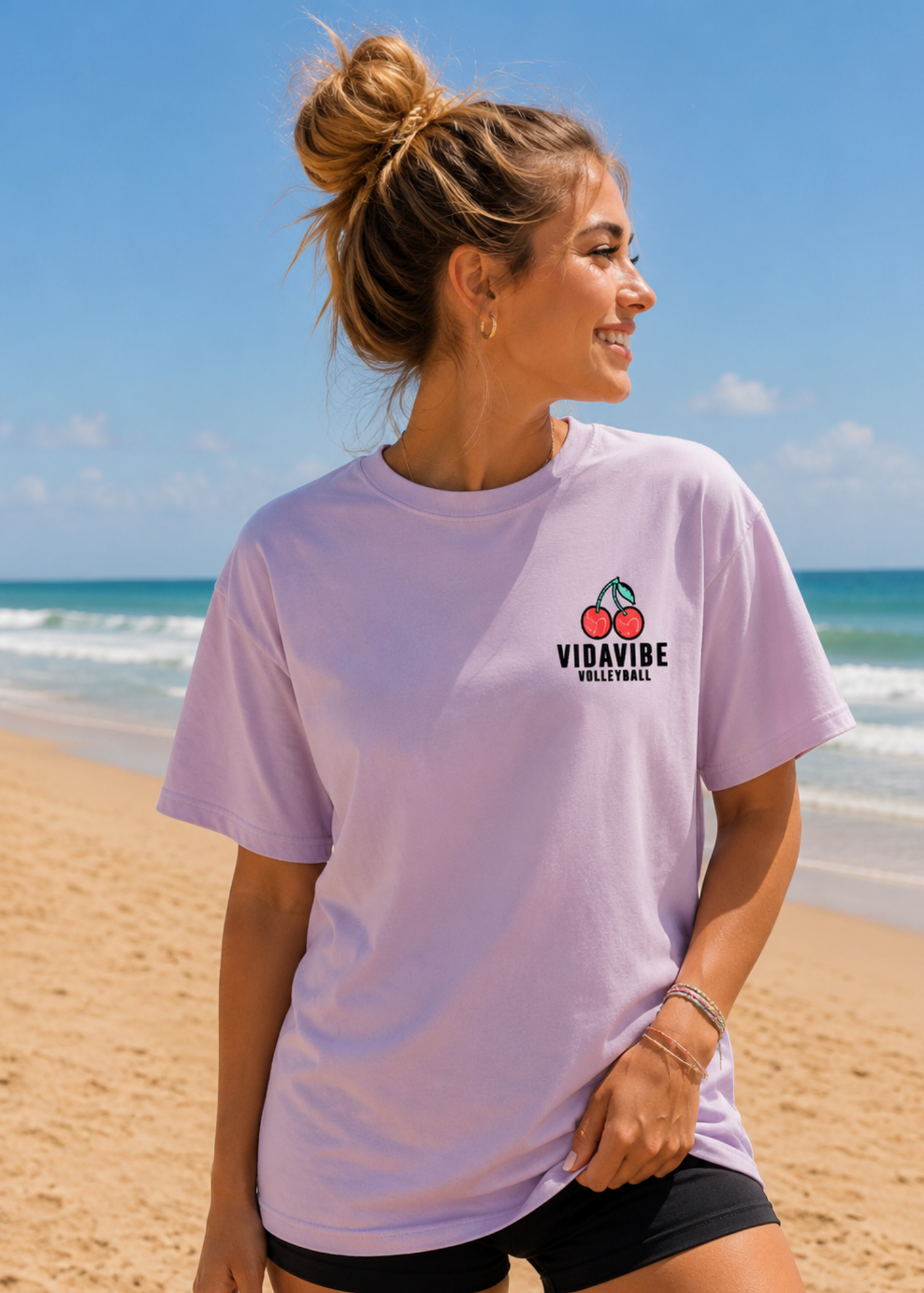 Woman wearing a light volleyball purple t-shirt with a logo on a beach