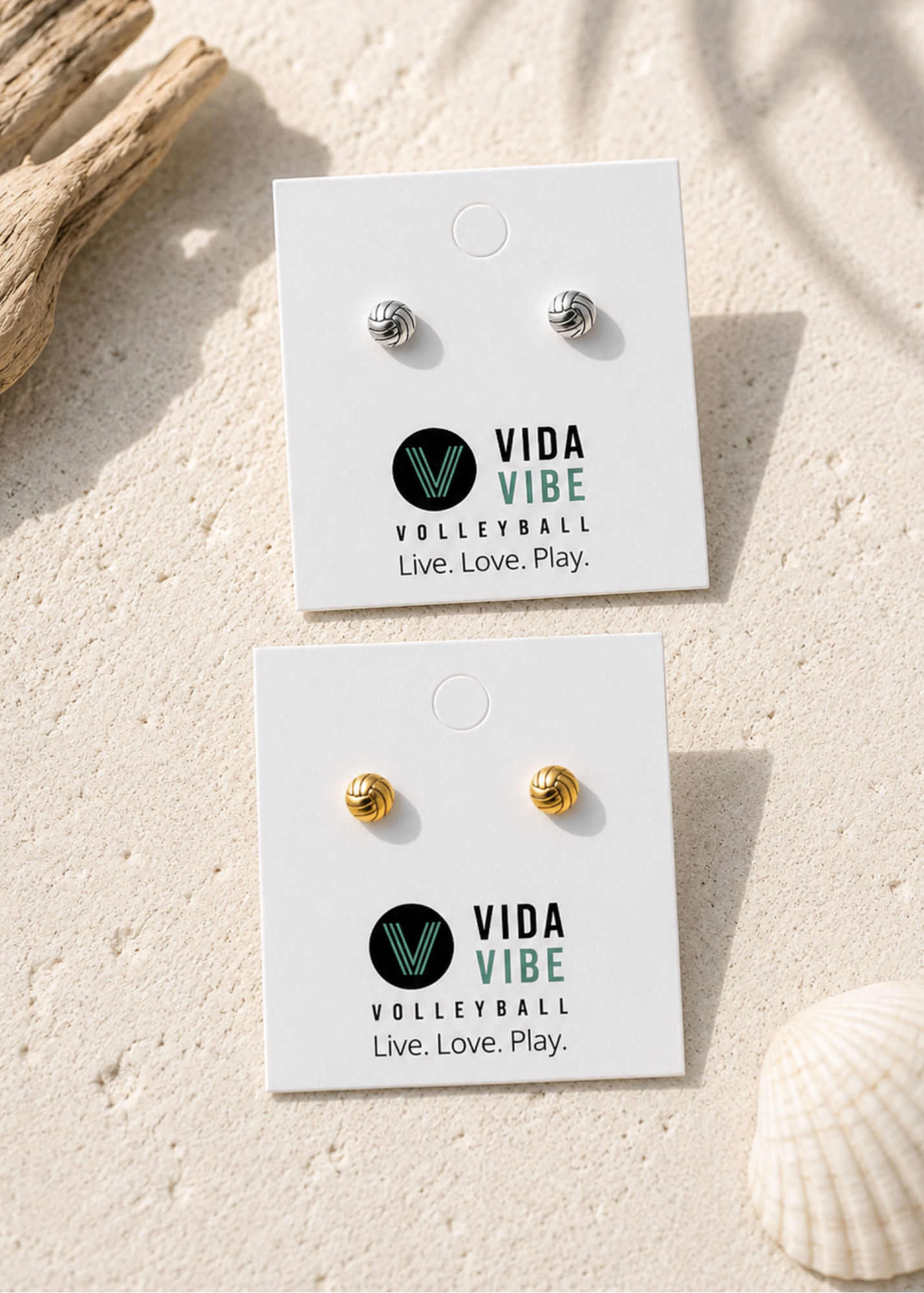 Vida Vibe Volleyball stud earrings on display with a sand background
