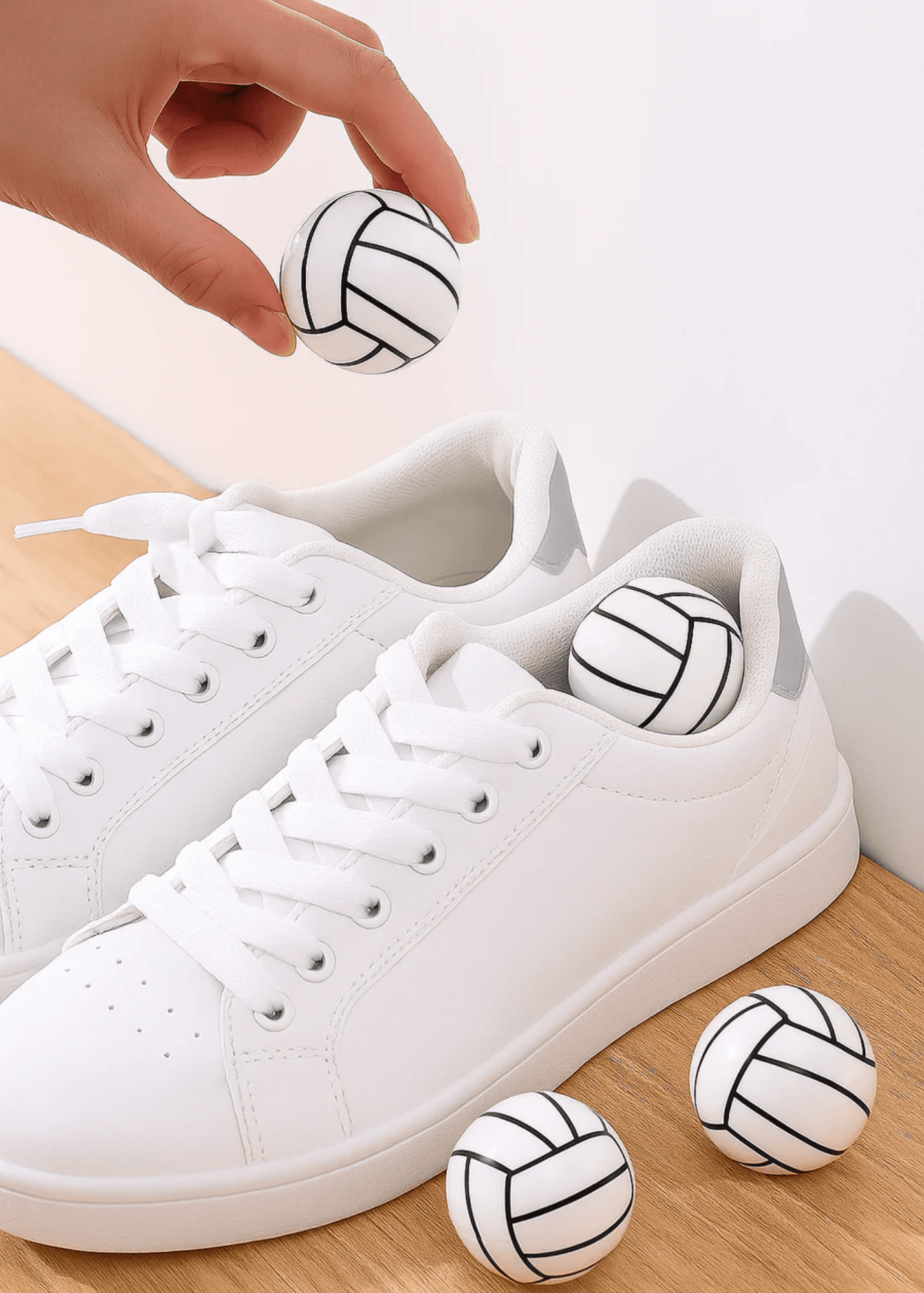 White sneakers with volleyball designs on a wooden surface